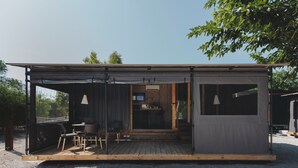 A compact, modern cabin with a covered outdoor seating area, a small kitchen, and a private entrance. - wecamp Jávea (Javea)