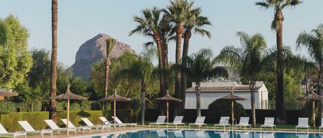 Een seizoensgebonden buitenzwembad en ligstoelen