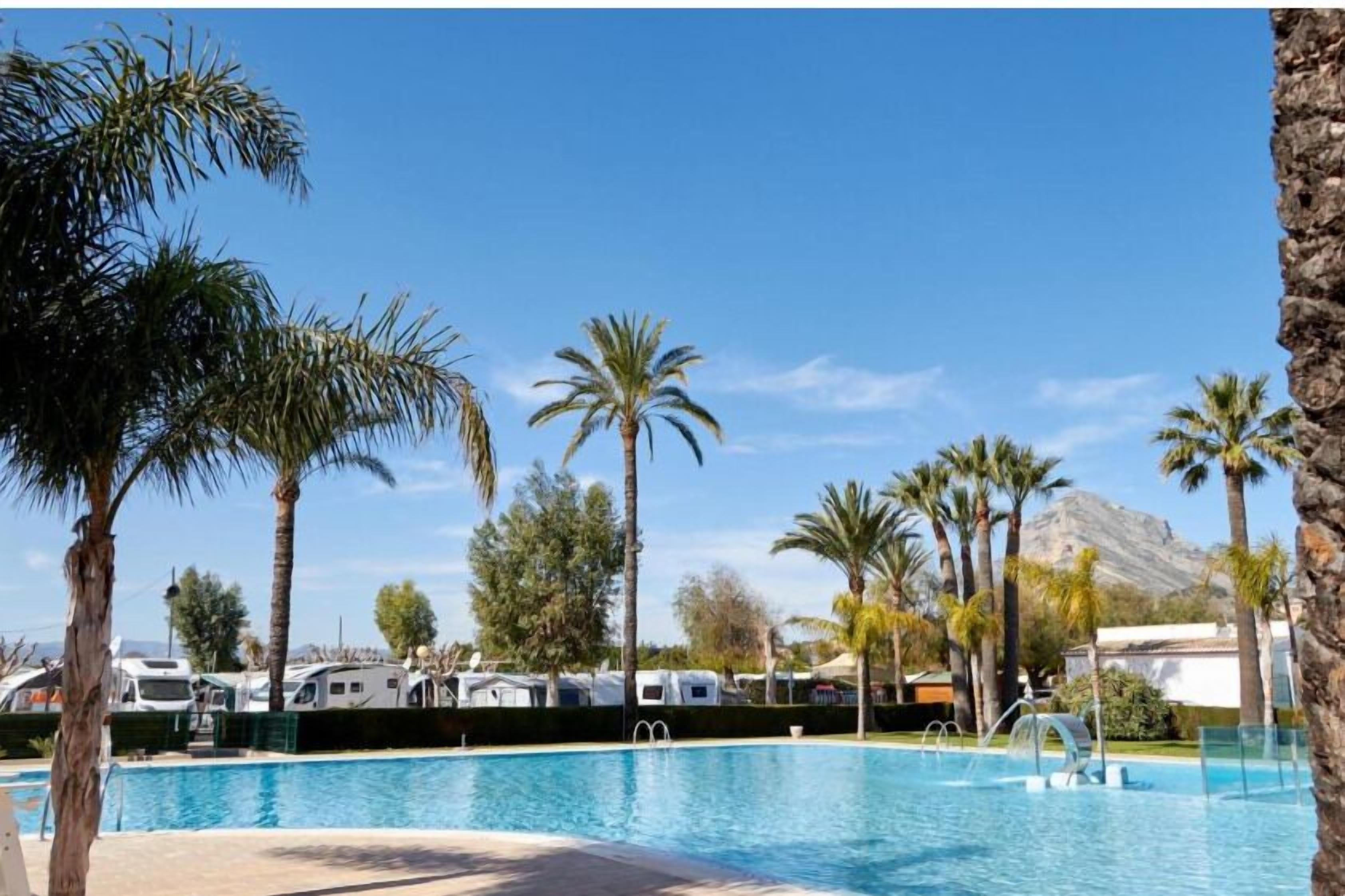 Een seizoensgebonden buitenzwembad en ligstoelen