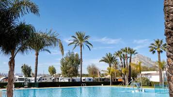 Een seizoensgebonden buitenzwembad en ligstoelen