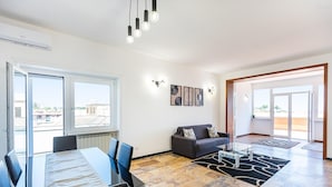 Una sala de estar moderna con comedor, ventanas amplias y vistas a la ciudad.