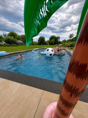 A swimming pool with inflatable toys and a flag. - 360 m² country house with pool, fireplace & large garden near Leipzig (Frohburg OT Ottenhain)