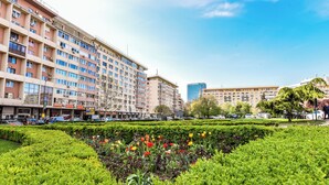 A multi-story building with a row of shops on the ground floor. - Grand Studio - Cismigiu Park (Bucharest)