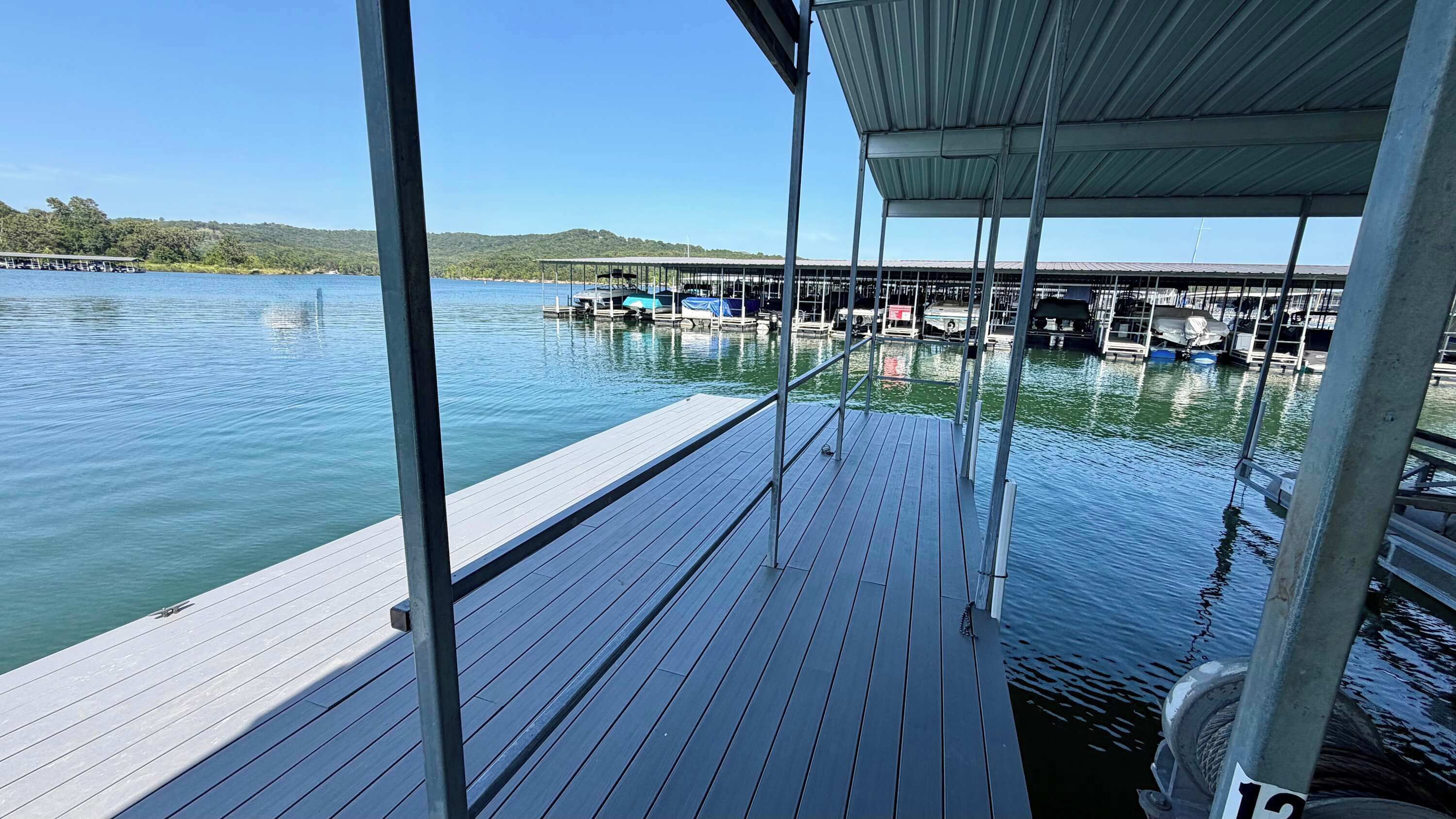 Une jetée en bois s’étendant sur une étendue d’eau calme, avec des bateaux amarrés au loin.