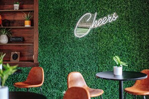 A cozy indoor setting with a green wall, wooden shelves, and leather chairs. - King Studio Stay in Afton w/ Desk + Private Entry (Afton)