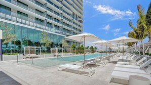 A modern hotel with a rooftop pool, sun loungers, and umbrellas. - New 1Bed 2bath 20th floor amazing views (Miami Beach)