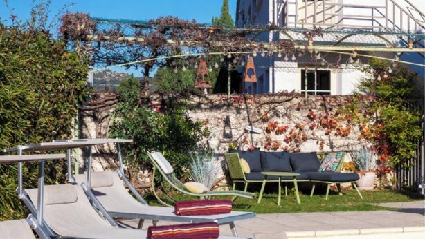 A hotel with a pool area featuring sun loungers and a garden view. - Hotel Le Castellan (Istres)
