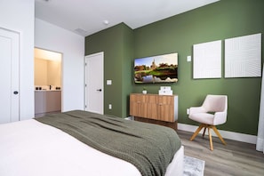 Une chambre à coucher moderne avec un lit, une télévision, une armoire en bois et une chaise.