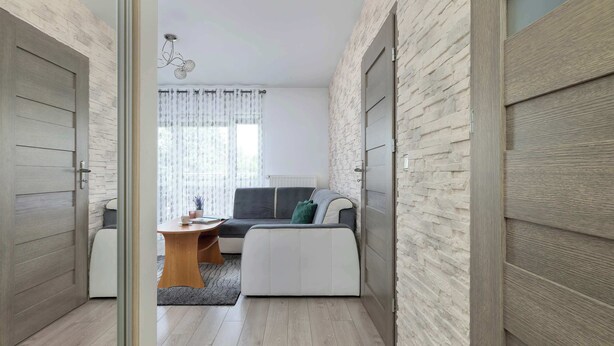 Ein modernes Wohnzimmer mit einer Couch, einem kleinen Tisch und einer Lampe.