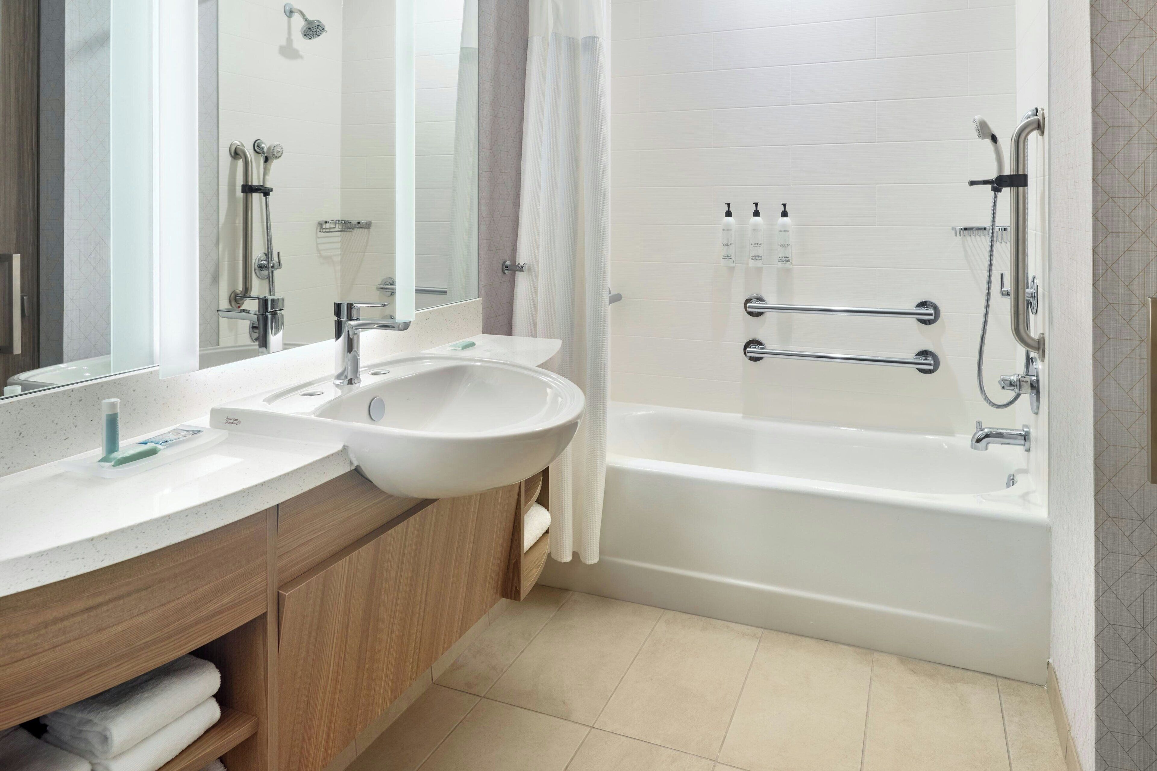 Ein modernes Badezimmer mit einem großen Waschbecken, einem Spiegel und einer Badewanne.