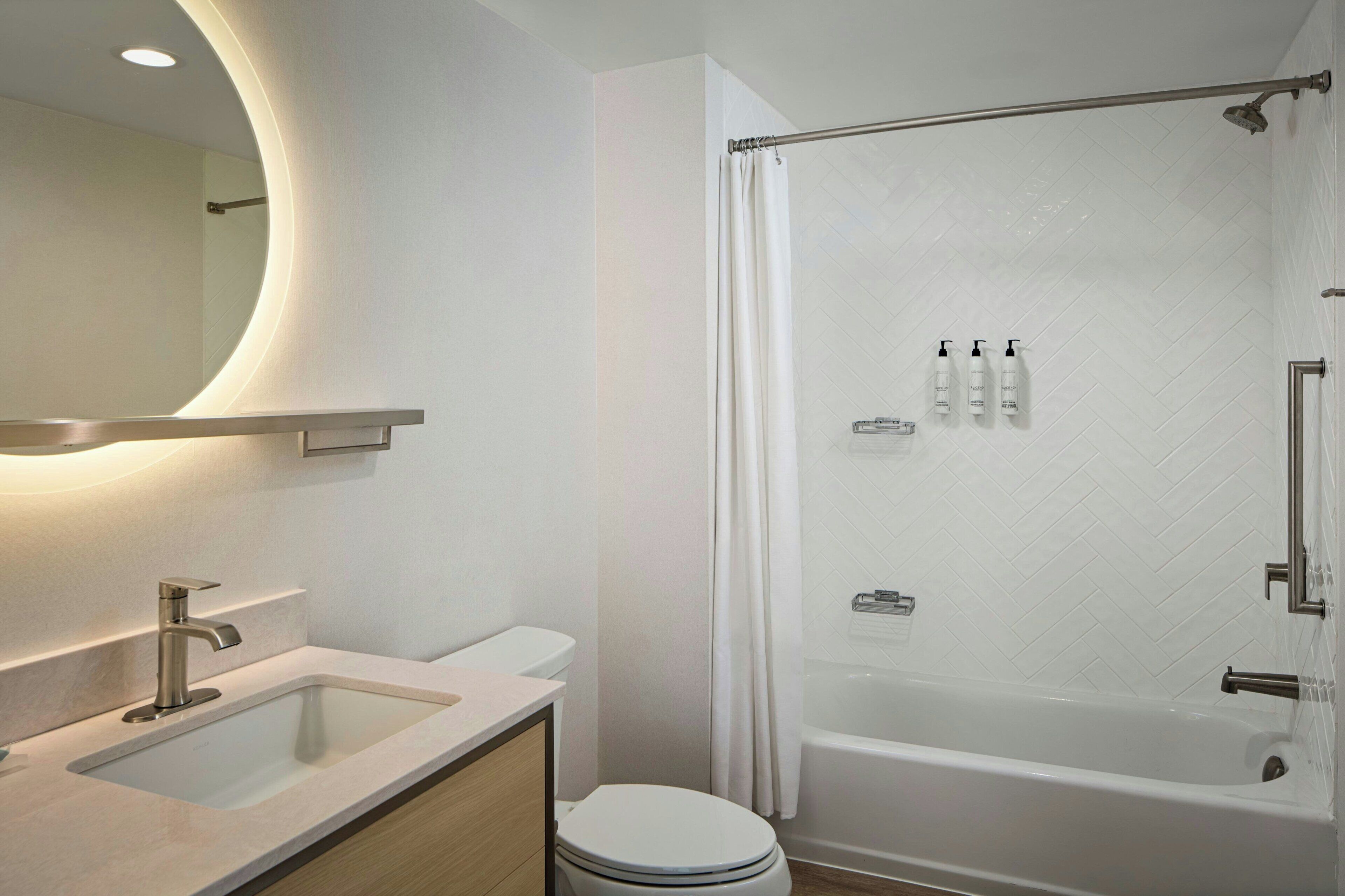 Un baño moderno con bañera, inodoro, lavamanos y zona de ducha.