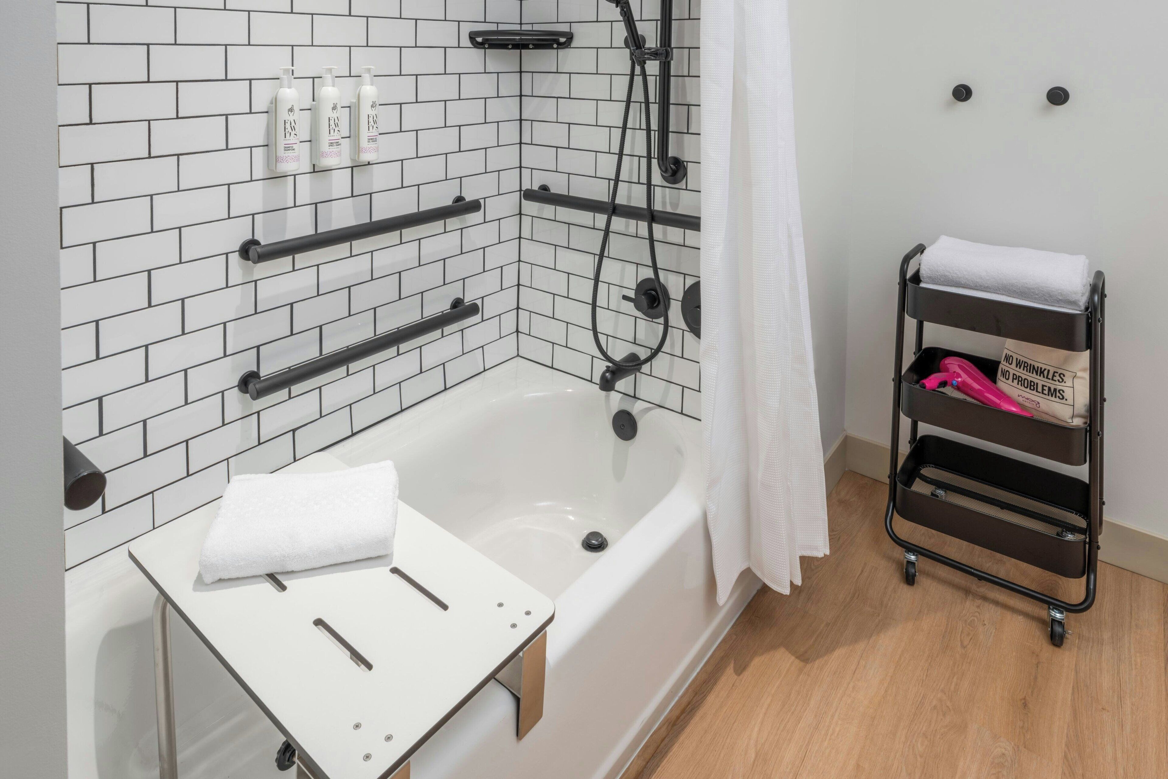 Un baño moderno con una bañera blanca, un perchero para toallas y una zona de ducha.