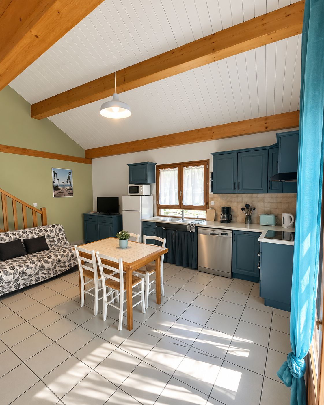A compact kitchen with a dining area, wooden beams, a refrigerator, microwave, and a sink.