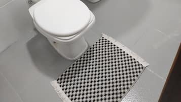 Chuveiro, toalhas de banho, sabonete, papel higiênico
