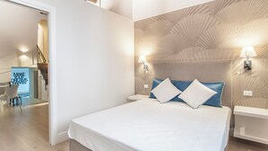 Et moderne soveværelse med en stor seng, to sengeborde med lamper og en væg med struktur.