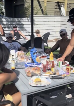 A group of people seated at an outdoor table with various food items and condiments. - The Retreat in Santa Rosa Beach-Bungalow A (Santa Rosa Beach)