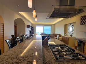 A modern kitchen with a central island, stainless steel appliances, and pendant lighting.