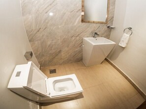 A compact bathroom with a toilet, sink, and mirror. - Cozy 1-bedroom apartment in nice Nairobi with fitness room (Nairobi)