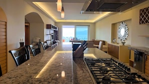 A modern kitchen with a central island, stainless steel appliances, and pendant lighting.