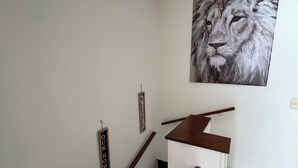 A staircase with wooden steps and a metal handrail, leading to a landing with a white wall. - Spacious 4-Bedroom House with AC, Double Parking & Coffee Region Charm (Pereira)