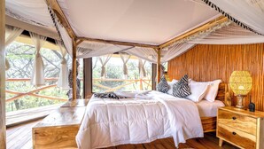 Une chambre à coucher avec un grand lit, un plancher en bois et un lit à baldaquin.