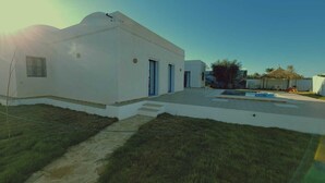 A white building with a flat roof, a small front porch, and a pool area. - Dar Asteroth, Villa for rent Djerba, Ghizen (Ghizen)