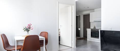 A modern apartment with a dining area, a living room, and a kitchen.