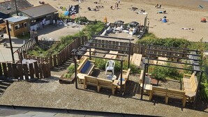 Un restaurant situé en bord de mer, avec une terrasse et vue sur la plage.