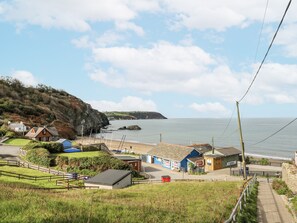 A coastal village with houses, a beach, and a cliff. - Awel Deg, Tresaith (Cardigan)