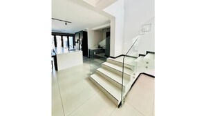Een modern interieur met een trap naar een hoger niveau, een keukenhoek en een eetruimte.