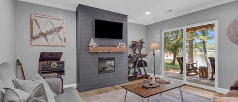 A living room with a fireplace, a flat-screen TV, a sofa, and a coffee table.