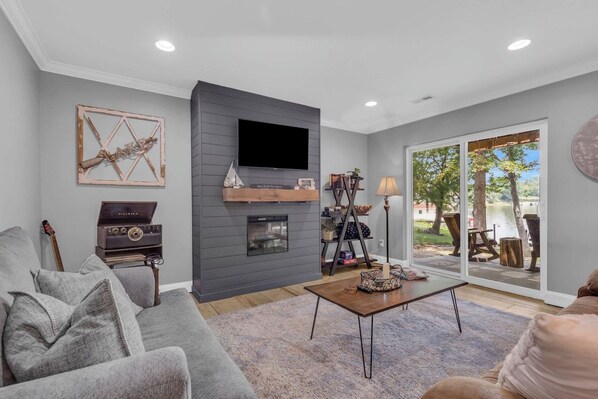 A living room with a fireplace, a flat-screen TV, a sofa, and a coffee table.