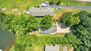A residential property with a large house, a driveway, and a body of water.