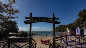 Un camino de madera que lleva a una playa, con un letrero que dice 'Printado de Pescador'.