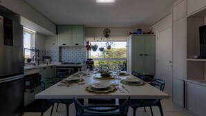 Una cocina moderna con comedor listo para una comida, que incluye una isla grande, armarios y vistas por la ventana.