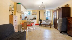 Un espacio habitable compacto con kitchenette, comedor y sofá.