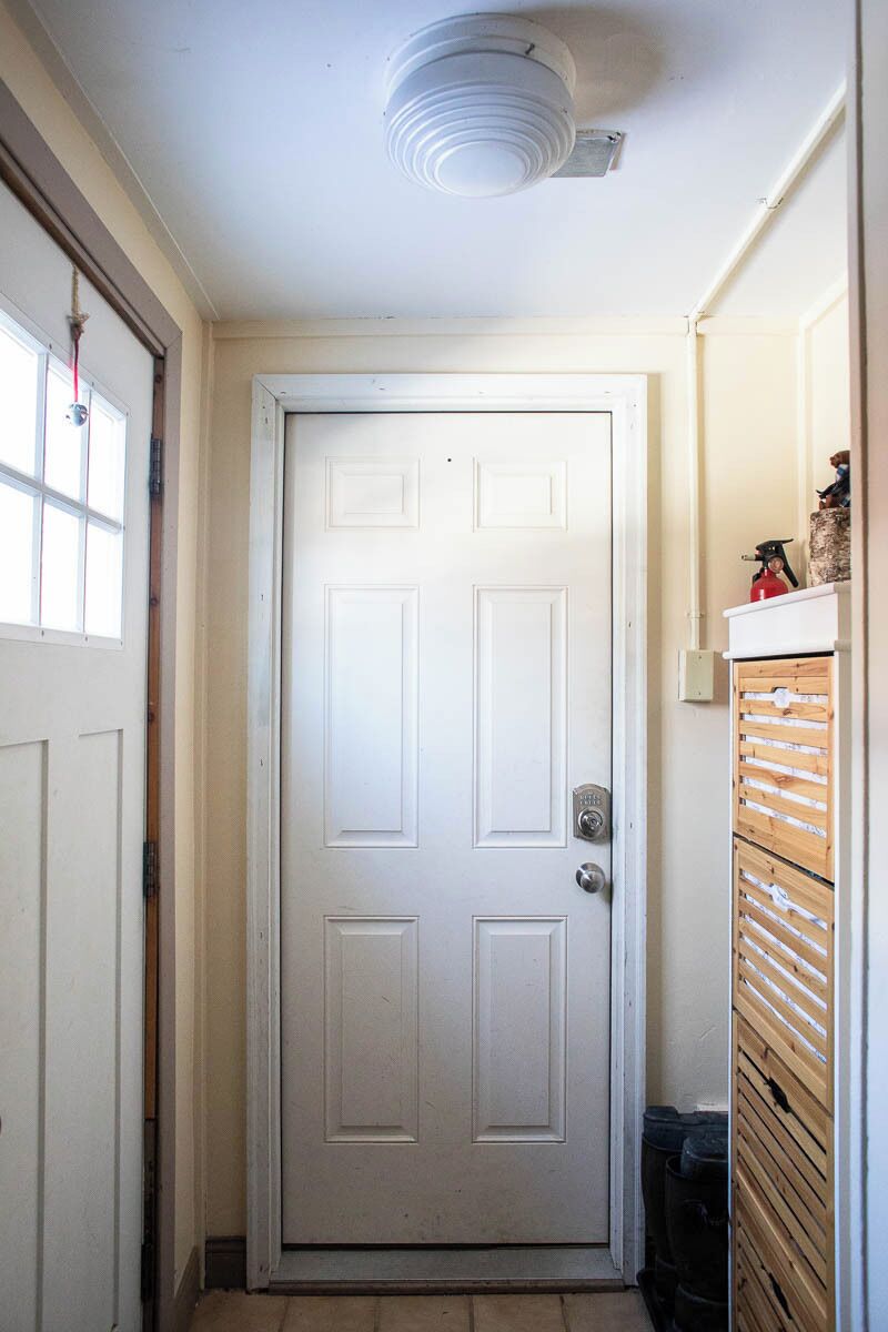 A white door with a keyhole and a doorbell.