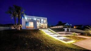 A modern two-story house with a well-lit exterior, a paved driveway, and a landscaped lawn. - Perfect villa Stressless with beautiful pool in charming Smoković (Smoković)
