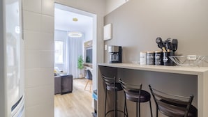 Una cocina moderna con barra, electrodomésticos de acero inoxidable y una cafetera.