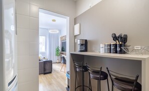 Una cocina moderna con barra, electrodomésticos de acero inoxidable y una cafetera.