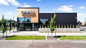 Een modern gebouw met een bord waarop 'UPRISE BREWING CO.' staat.