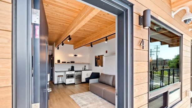 Een modern interieur met een keuken, een bank en een balkon.