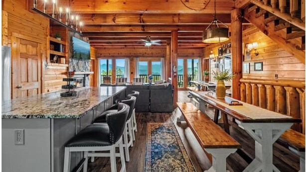 A spacious kitchen with a granite countertop, bar seating, and a large island. - Luxury-8BR-Lodge-Game Room-Theater&MountainViews (Sevierville)