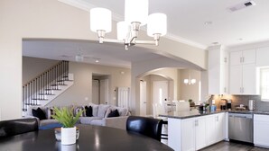 A modern kitchen with white cabinets, a dark countertop, and a built-in dishwasher. - Tranquil 3-bedroom house with dock in Kemah (Kemah)