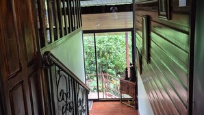A wooden staircase leading to a balcony with a view of greenery. - Villa Azul  (Quesada)