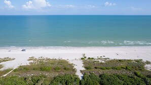A beach with white sand and clear blue water.