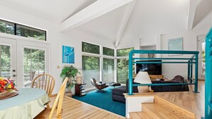 Ein modernes Interieur mit Essbereich, einer Couch, einem Fernseher und einer Treppe.