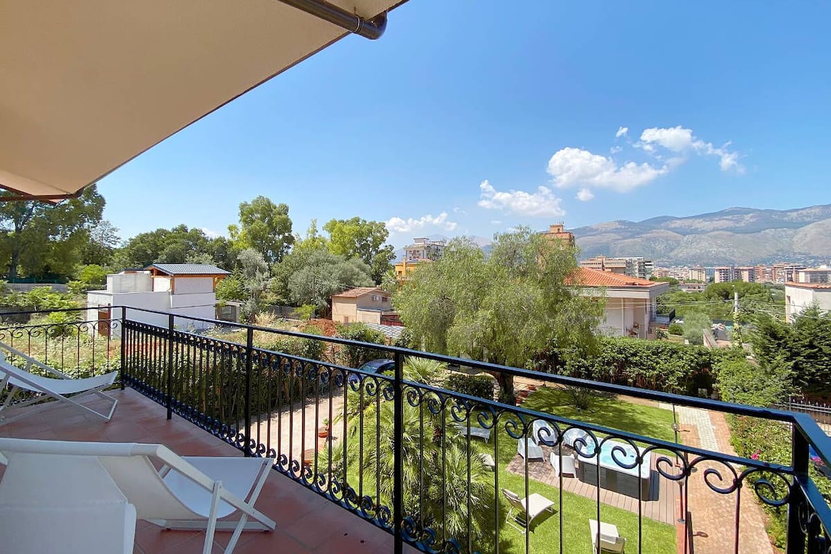 A balcony with a view of a residential area, including houses and greenery.