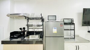 A modern kitchen with a stainless steel refrigerator, a built-in oven, and a microwave.