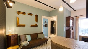 Ein Wohnzimmer mit braunem Sofa, einem gemusterten Boden und an der Wand befestigten Bilderrahmen.